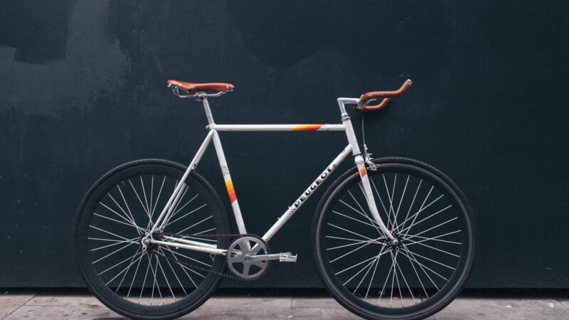 gray fixie bike leaning on black wall